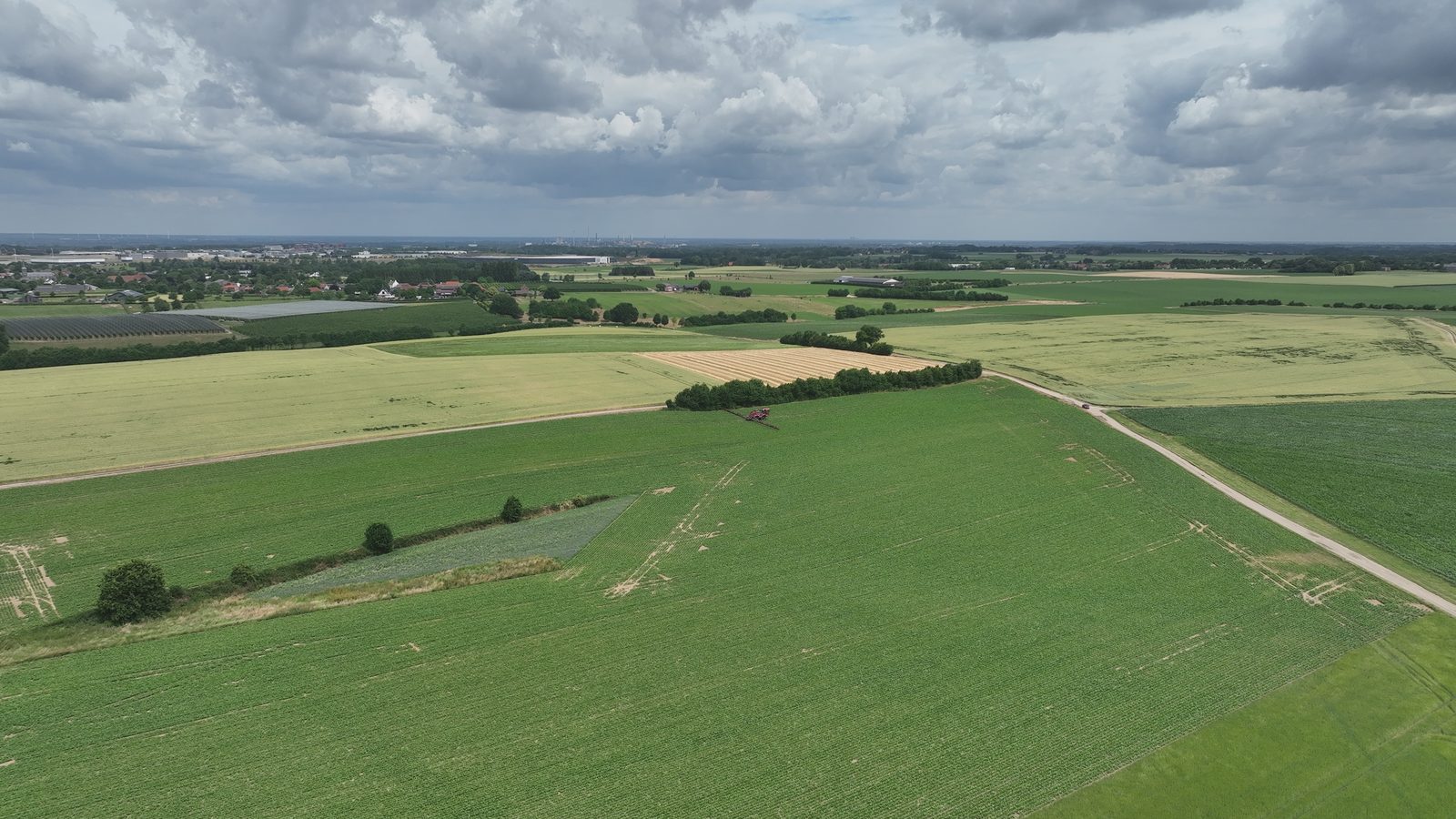 Piloot en loonwerker bij de veldspuit, drone op de grond ernaast