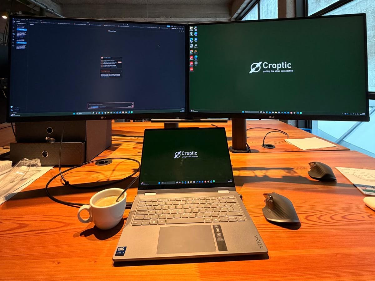 Werkplek bij Croptic in Gent: twee schermen en een laptop met het Croptic-logo